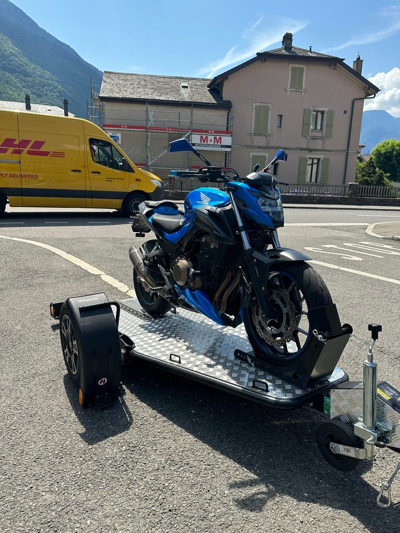 Remorque Lorries MT-1 avec moto chargée, vue de face, stationnée dans une rue de Martigny